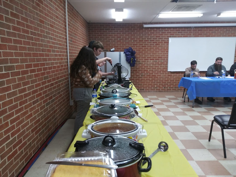 Line of Crock pots on a yellow table cloth