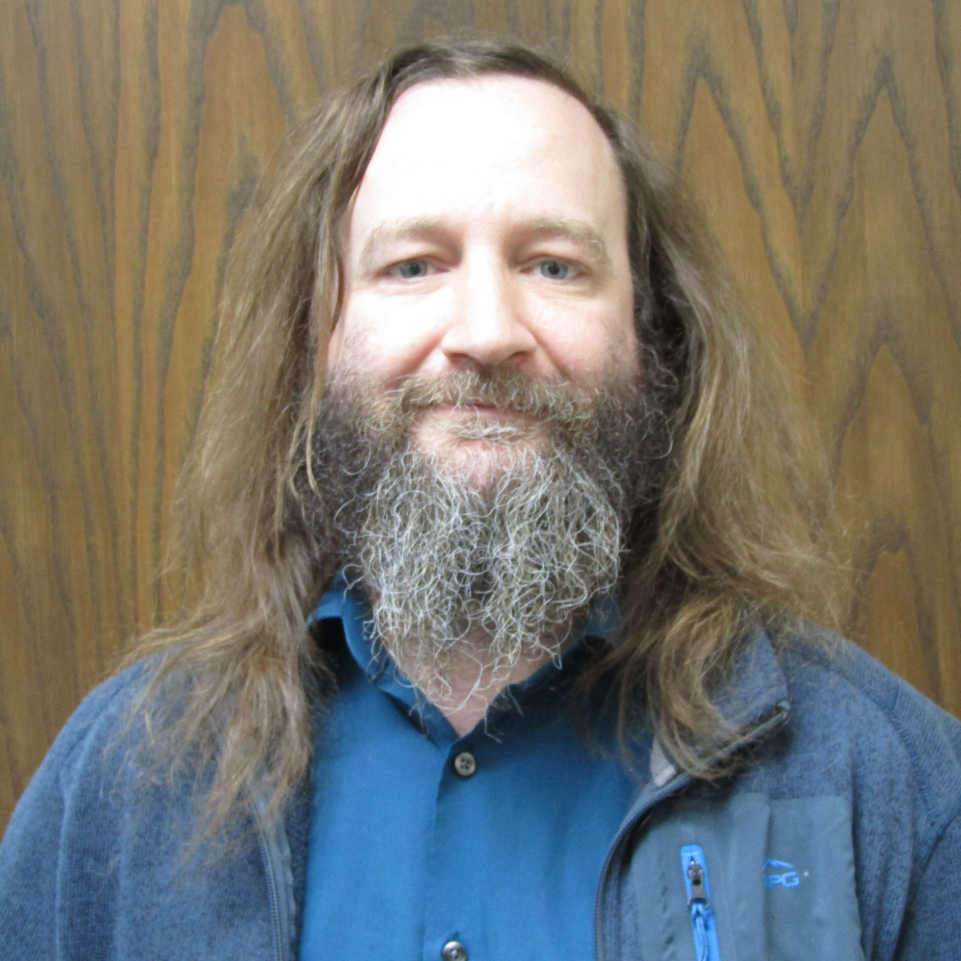 Man with brown long hair and gray brown beard.