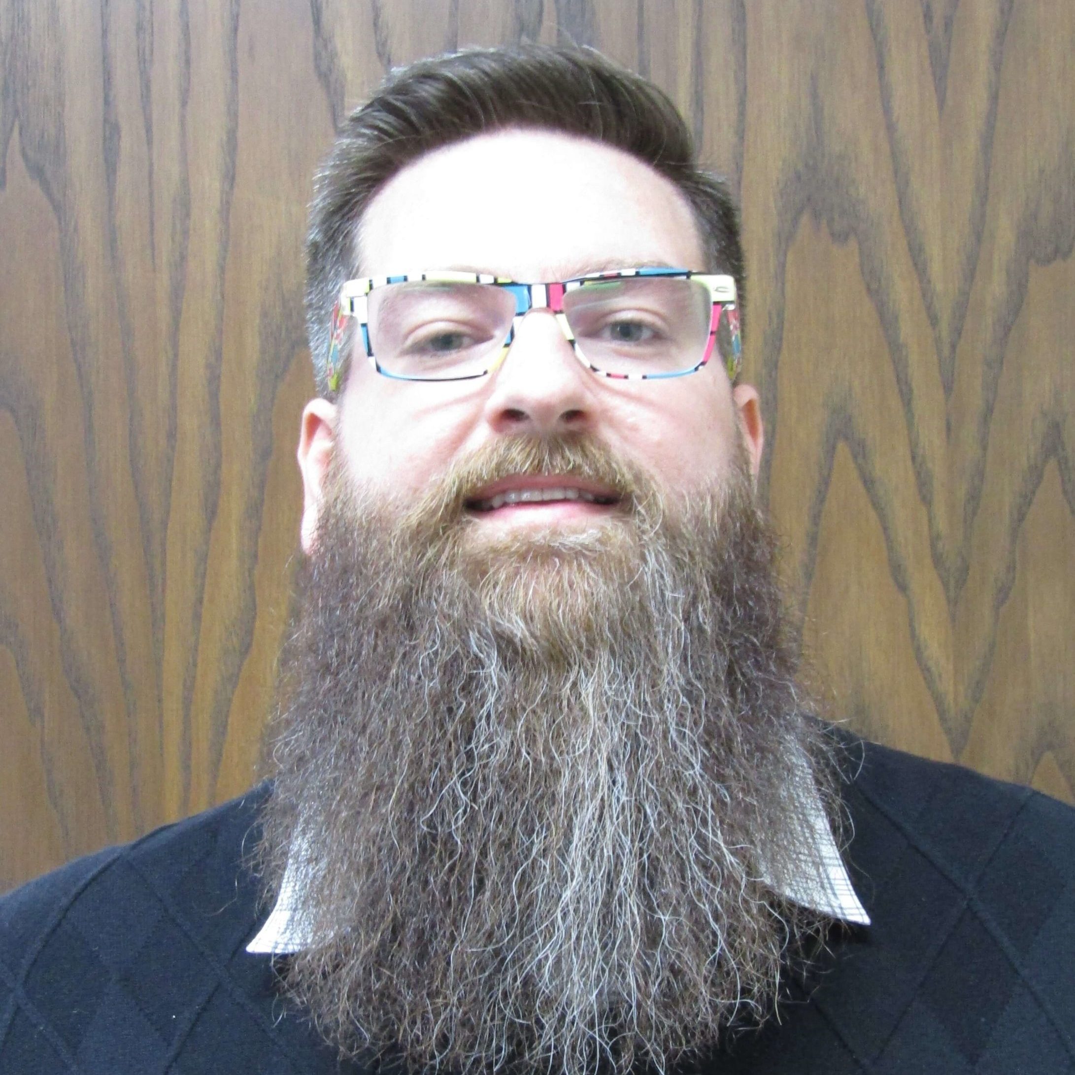 Man with long beard and wearing glasses